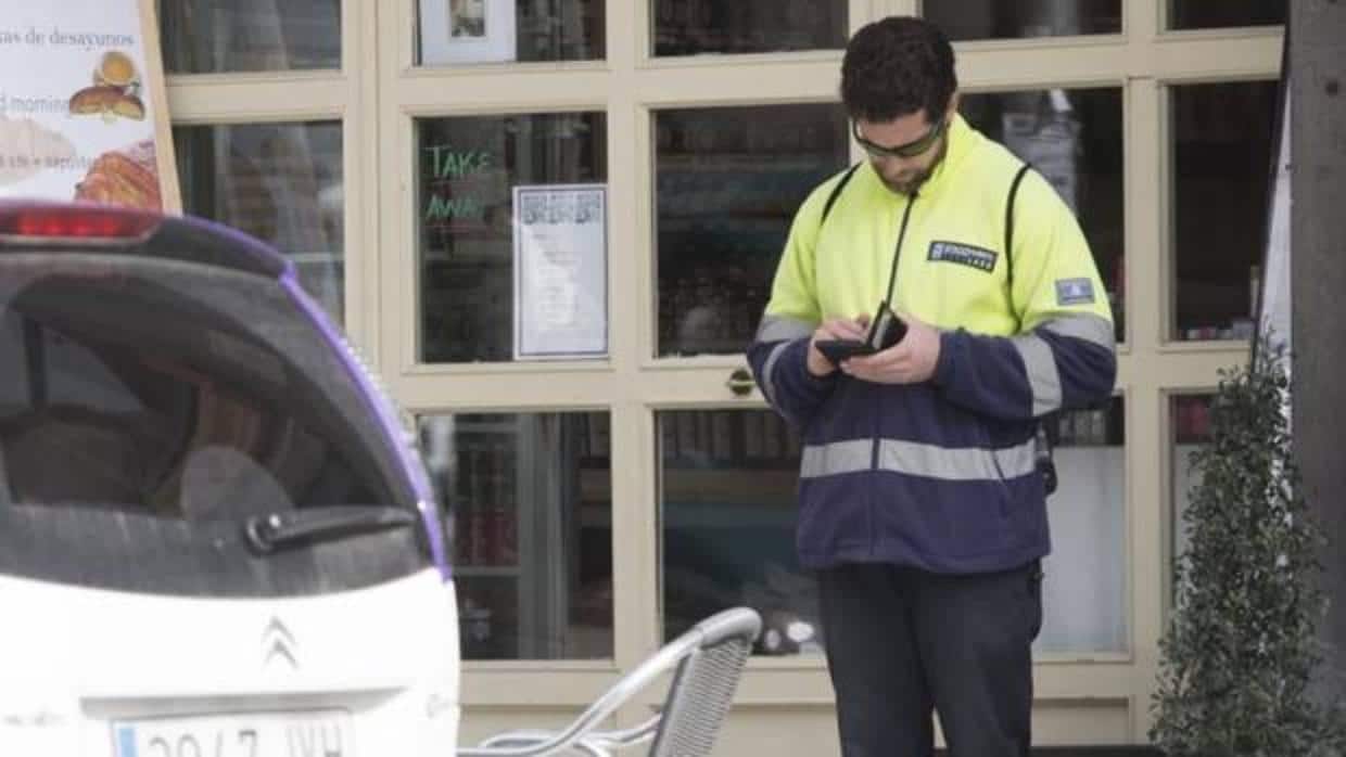 Un agente del SER pone una multa a un vehículo mal estacionado en Madrid