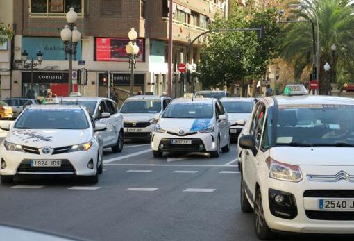 Varios taxistas circulando juntos durante la protesta, este lunes en el centro de Alicante