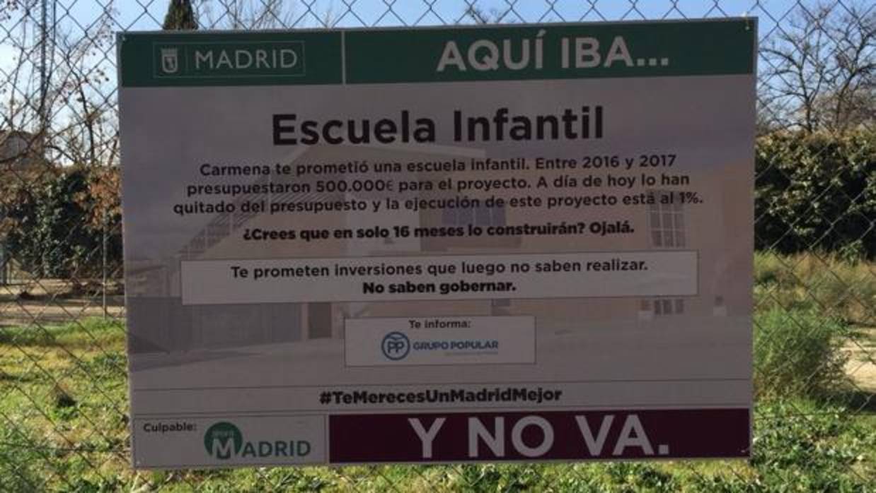 El cartel que ha colgado el PP en un solar de Arganzuela donde debería haber una escuela infantil