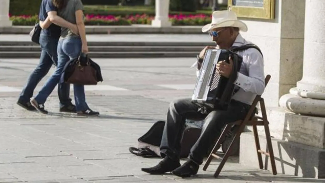 Un músico callejero tocando en la plaza de Oriente