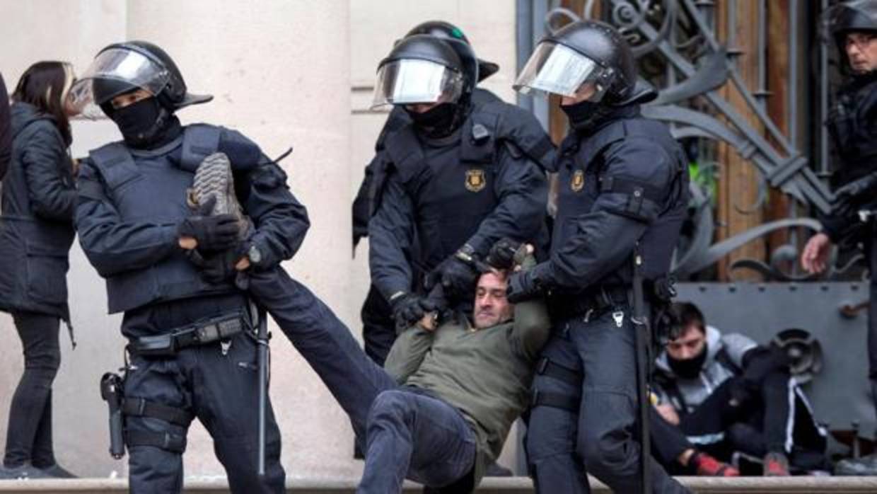 Los Mossos d'Esquadra detienen trasladan a uno de los activistas ante el Palacio de Justicia