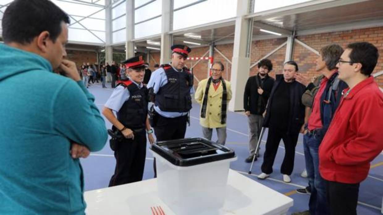Dos mossos frente a una mesa de votación en un colegio electoral del referéndum ilegal del 1-O