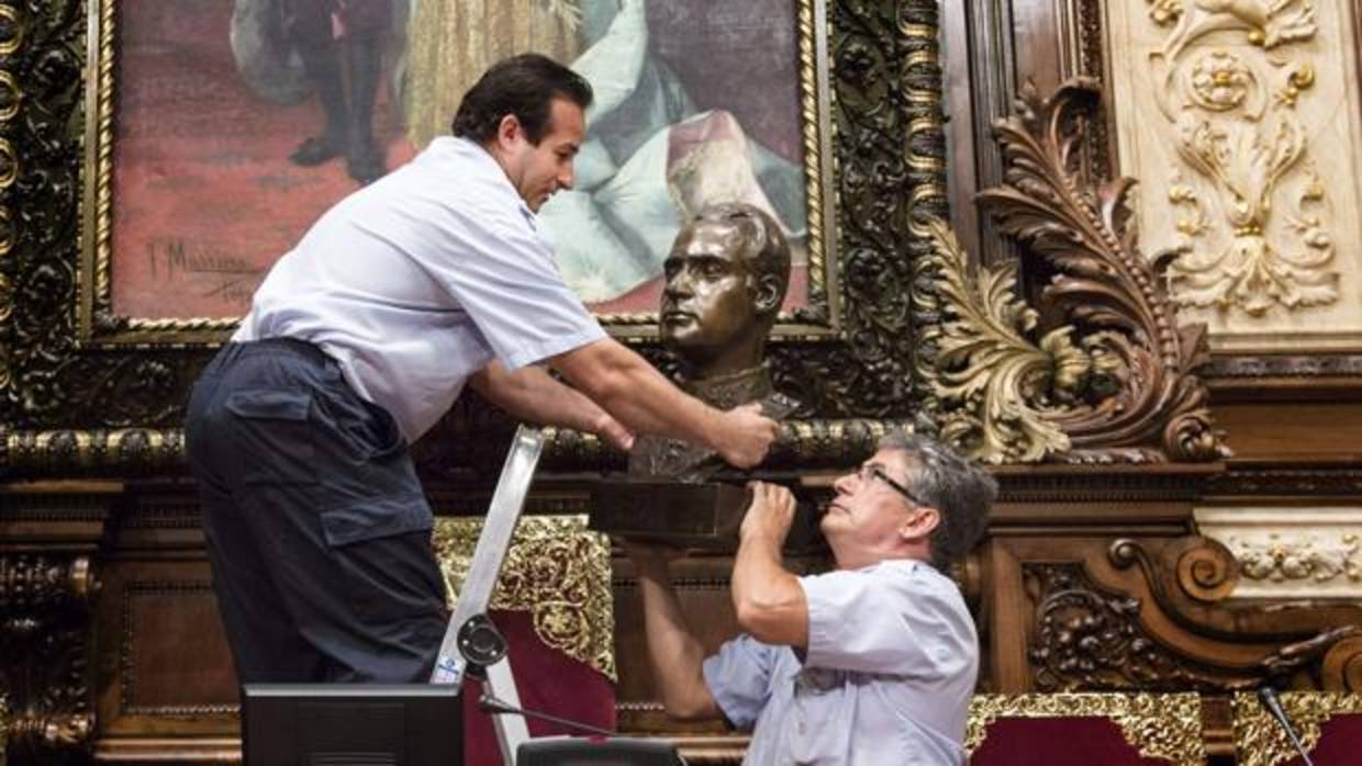 Dos operarios retiran el busto del Rey Juan Carlos del Salón de Plenos del Ayuntamiento