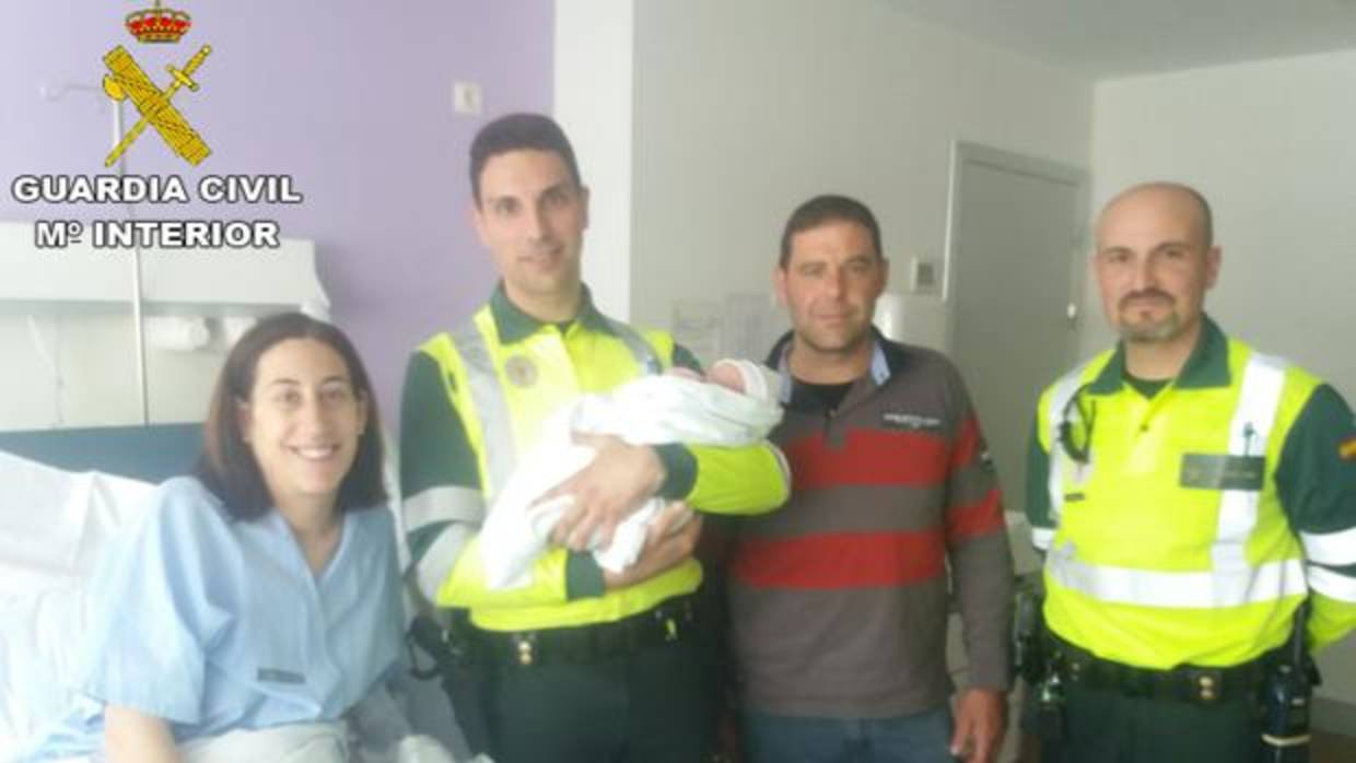 Imagen de los agentes junto al recién nacido y sus padres