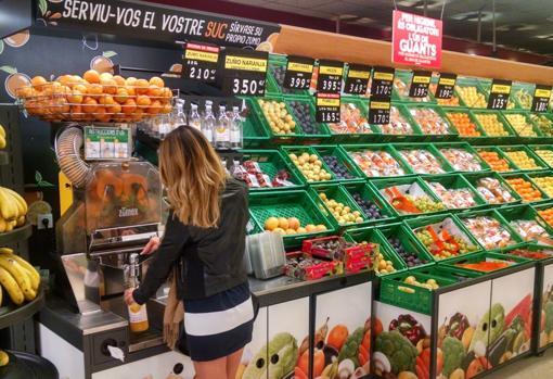 Imagen de una clienta dispensándose zumo de naranja en un supermercado de Mercadona