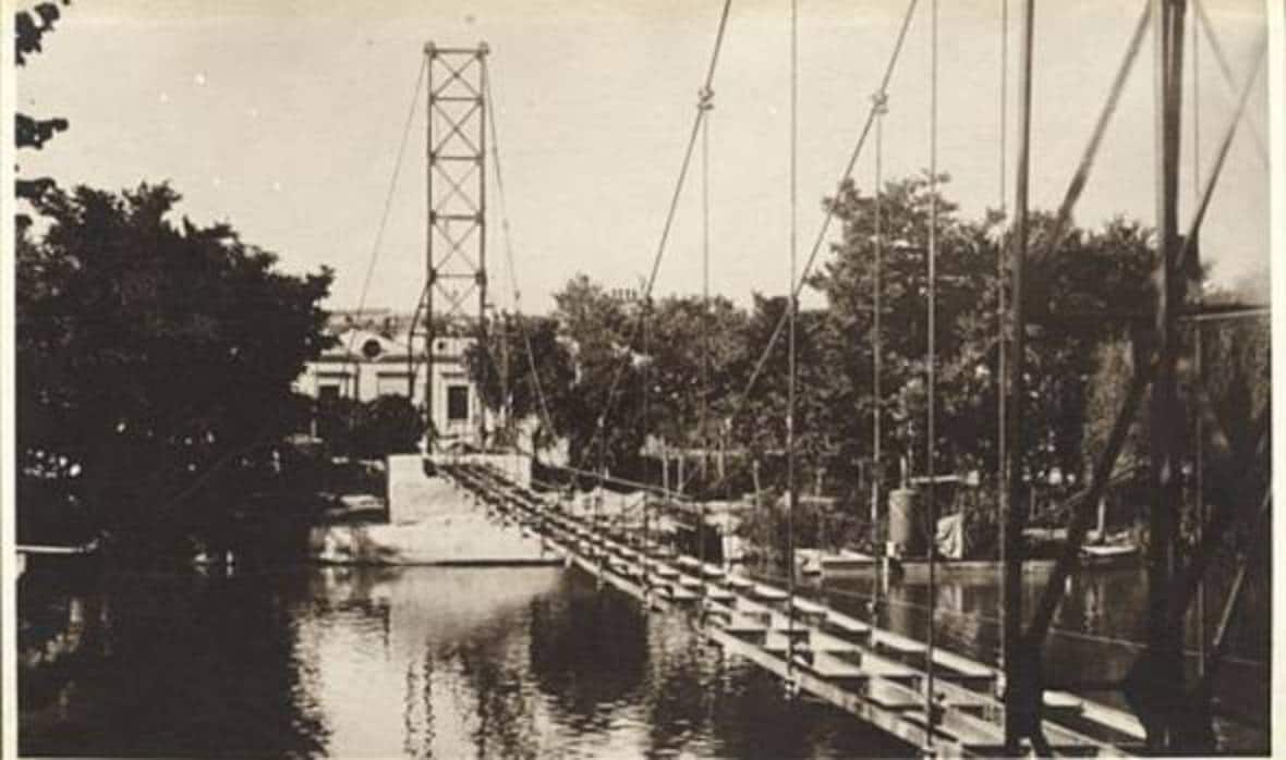 Pasarela colgante en construcción hacia 1925. Junto a la orilla, barca con la draga. Foto de José Vera. Archivo Municipal de Toledo