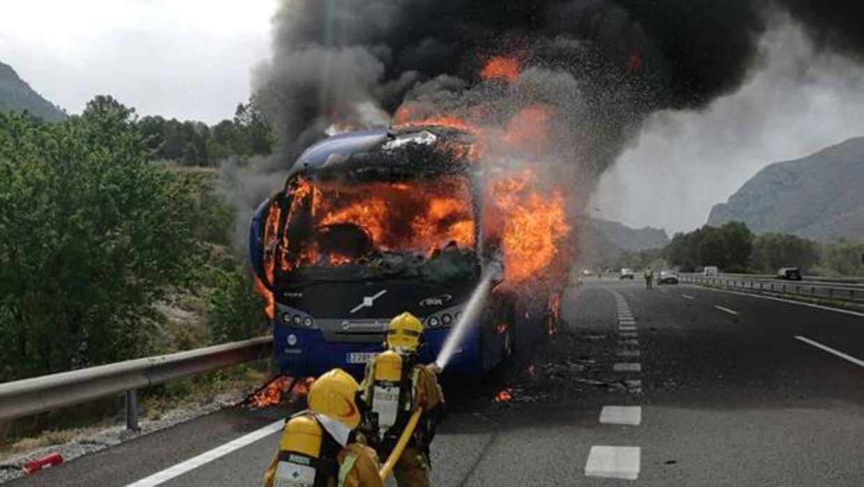 Bomberos extinguiendo las llamas que han destruido el autocar