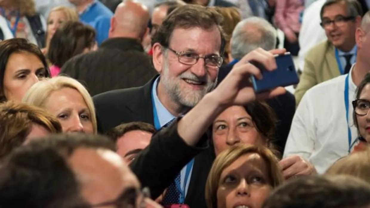 Mariano Rajoy se fotografía con un grupo de personas antes de la Convención Nacional del PP en Sevilla