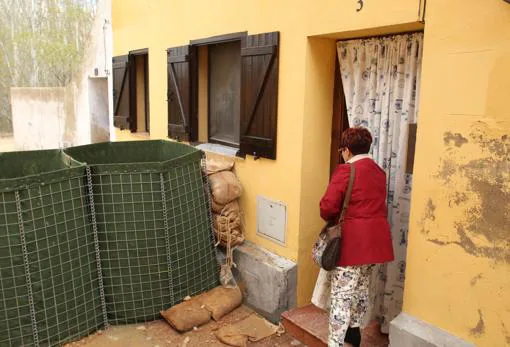 Una vecina de Novillas (Zaragoza) observa la barrera preventiva levantada ante su casa para protegerla de las aguas del Ebro