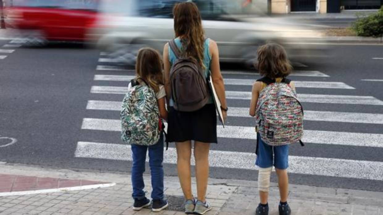 Una madre lleva a sus hijos a un centro educativo en Valencia