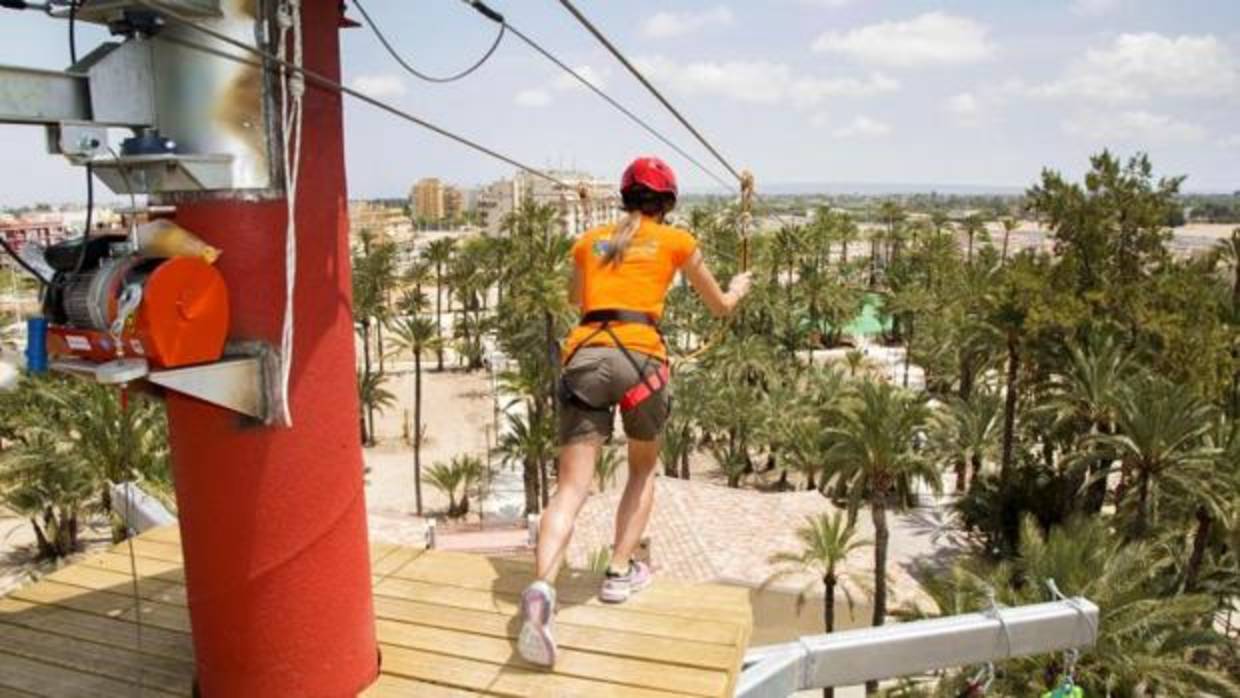 Una joven practica tirolina en el Parque Elche Aventura