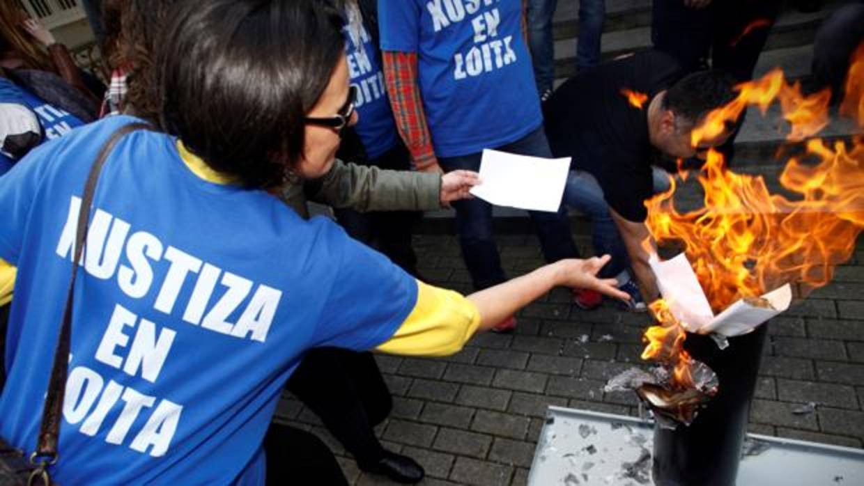 Trabajadores de Justicia, ayer en La Coruña, quemando sus nóminas en señal de protesta