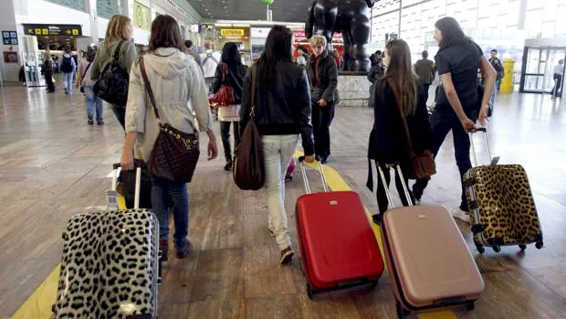 Jóvenes arrastran sus maletas en el aeropuerto
