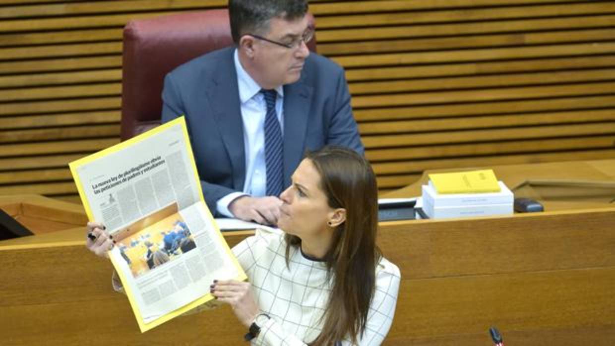 Beatriz Gascó muestra un recorte de prensa en las Cortes Valencianas, ante el presidente de la Cámara, Enric Morera