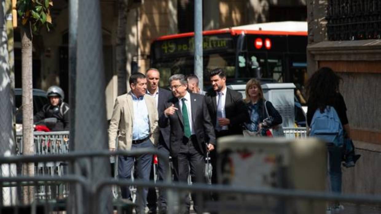 Enric Millo, en el centro de la imagen, esta tarde a su llegada a la sede de la Delegación