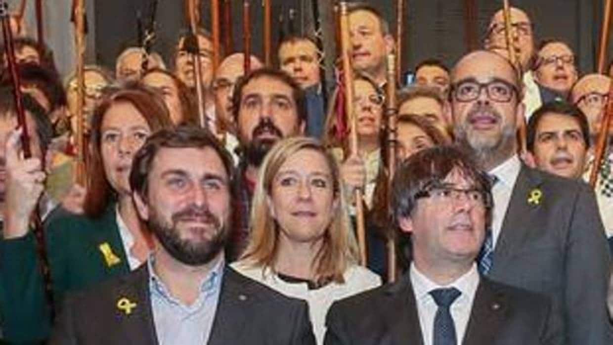 El exconsejero Antoni Comín, la expresidenta de la AMI Neus Lloveras, y el expresidente Puigdemont en un acto con alcaldes independentistas