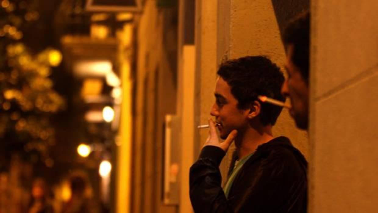 Dos jóvenes fumando un cigarrillo