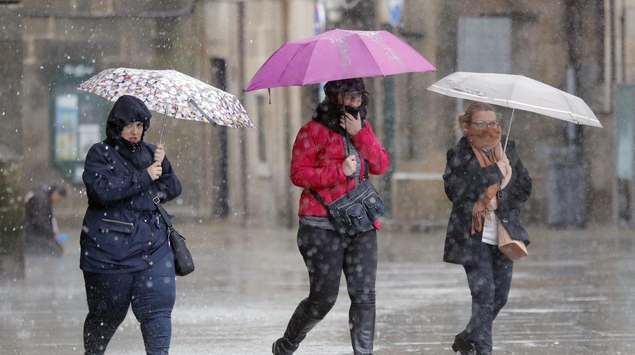 Varias personas caminan bajo la lluvia en la Plaza del Obradoiro.