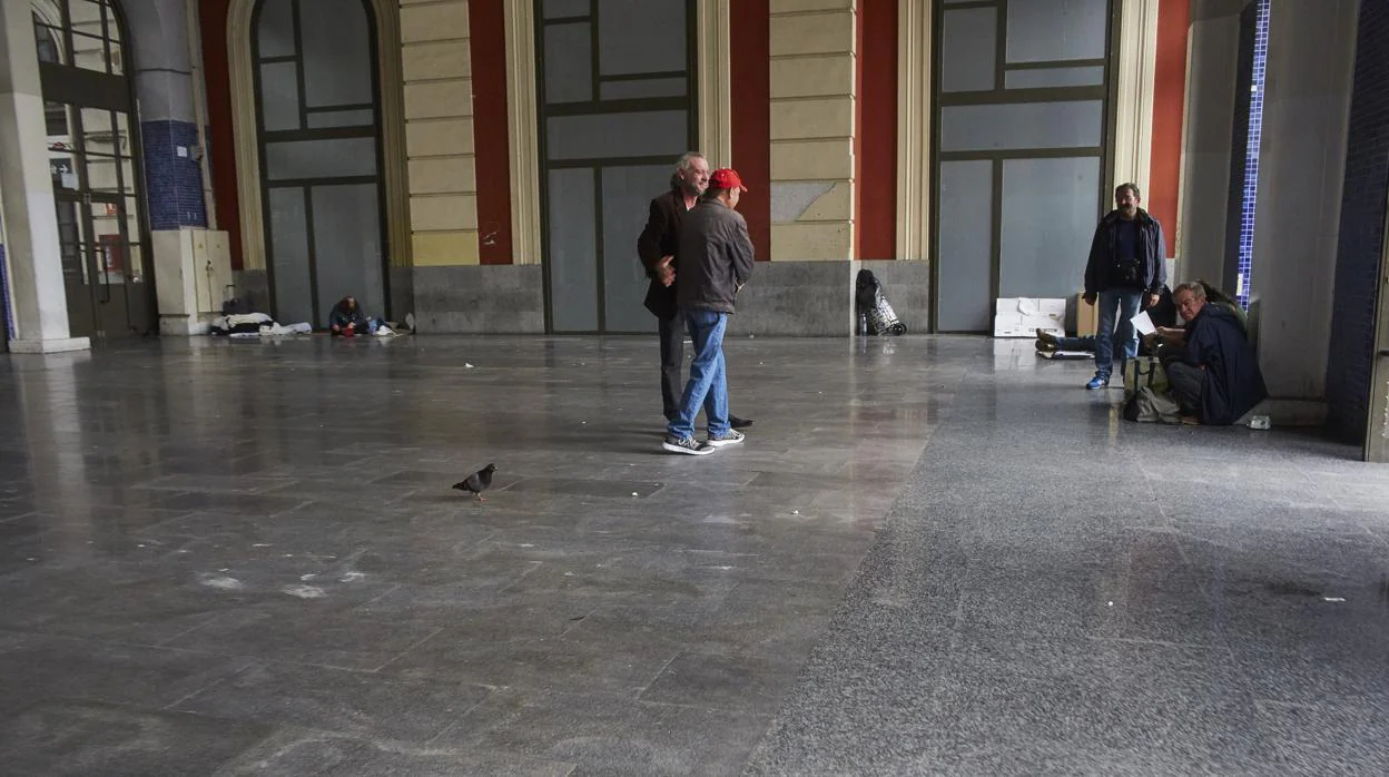 Un grupo de personas sin hogar en el vestíbulo de Príncipe Pio