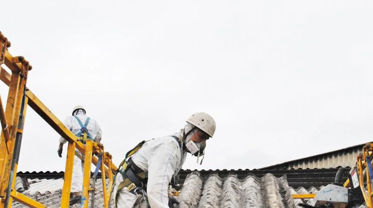 Operarios de una empresa especializada retirando un tejado de uralita