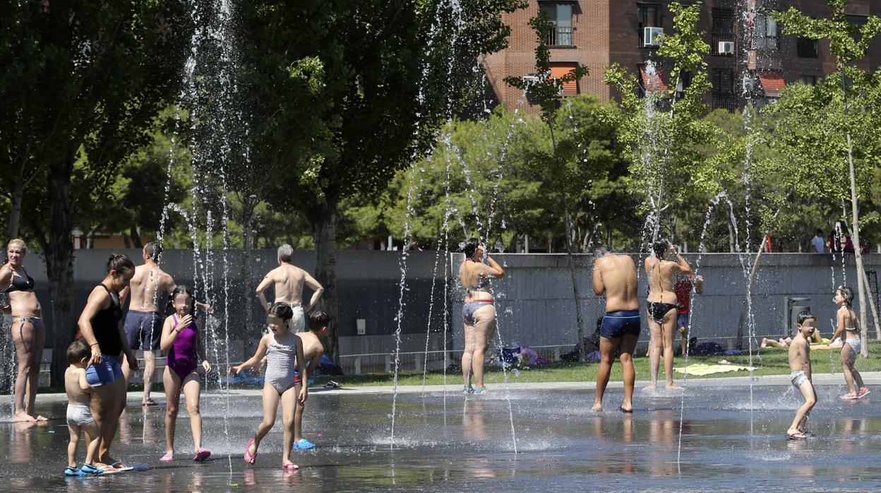 Niños y adultos combaten las altas temperaturas en una fuente de Madrid Río