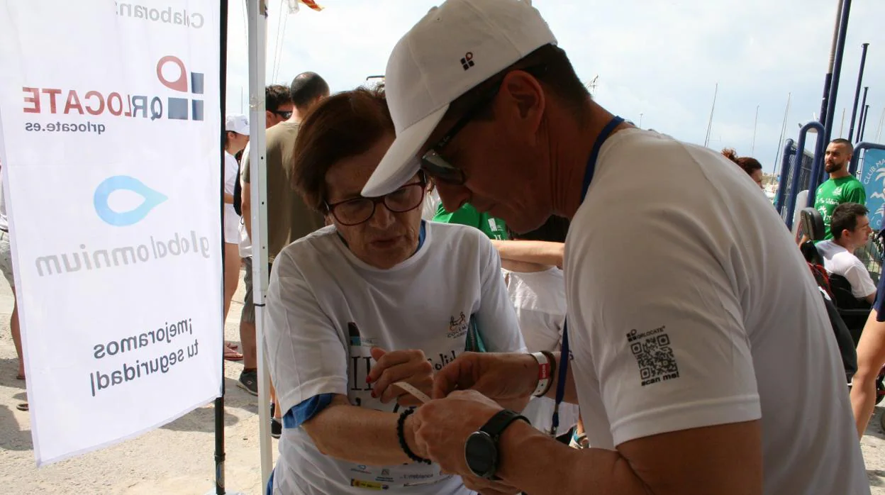 Una participante en La Mar Solidaria con su pulsera con código QR
