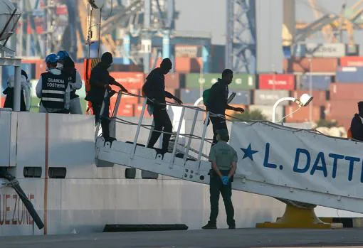 Tres inmigrantes descienden de uno de los barcos de la flotilla del Aquarius