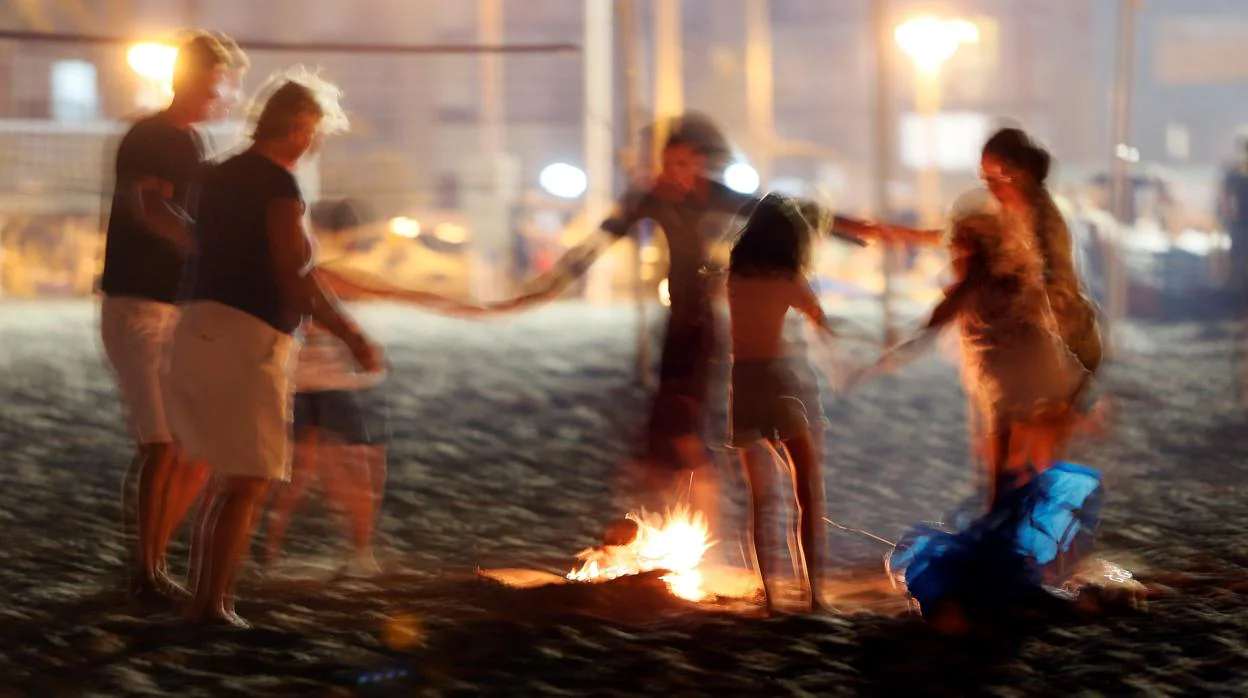Una familia gira en torno a una hoguera en una playa de Alicante por la Noche de San Juan