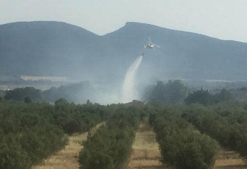 Descarga de agua desde una avioneta en los campos afectados por el fuego, en una imagen captada por un testigo difundida en Internet