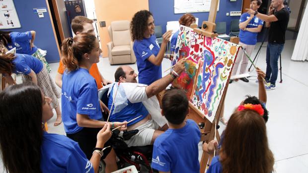 Los voluntarios de Global Omnium participan en un taller de pintura junto a personas con parálisis cerebral