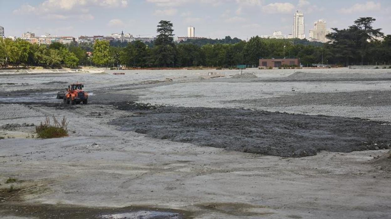 Una excavadora trabaja en el fondo del lago de la Casa de Campo, ayer