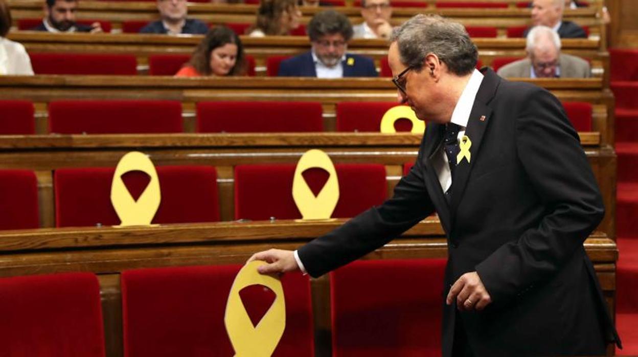 El presidente de la Generalitat, Quim Torra, coloca un lazo amarillo en el Parlament el pasado mes de mayo