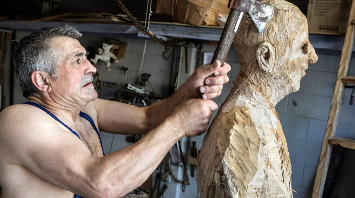 El escultor Álvaro de La Vega trabaja sobre una talla de madera en su taller