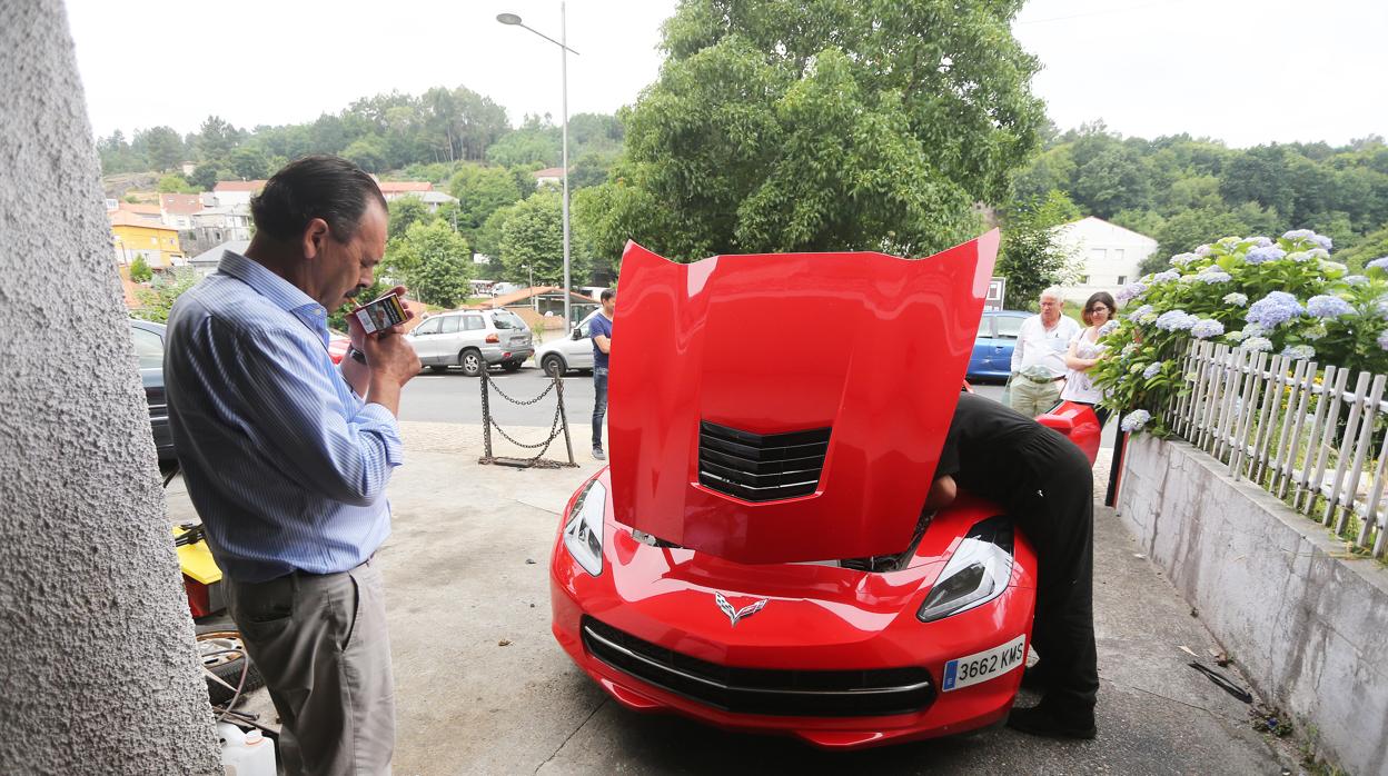 Un emigrante cambia las placas de la matrícula de su nuevo Corvette en un taller de la localidad