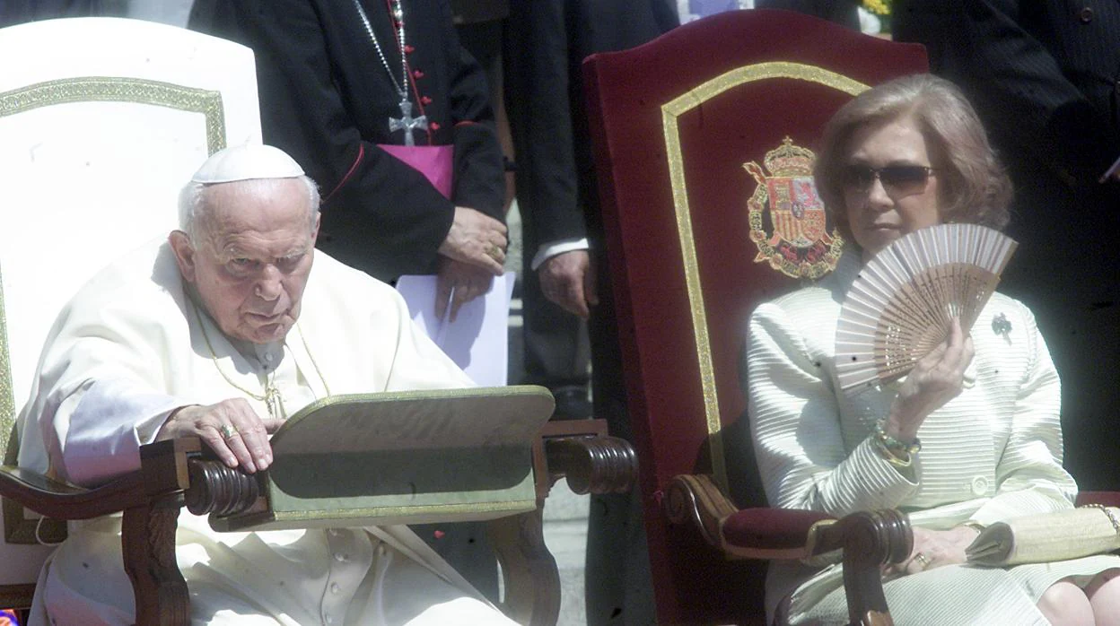 Arriba: Doña Sofía, durante la ceremonia de bienvenida al Papa Juan Pablo II en 2003. Abajo, la Reina junto al Rey durante la entrega de reales despachos en la Academia Central de la Defensa