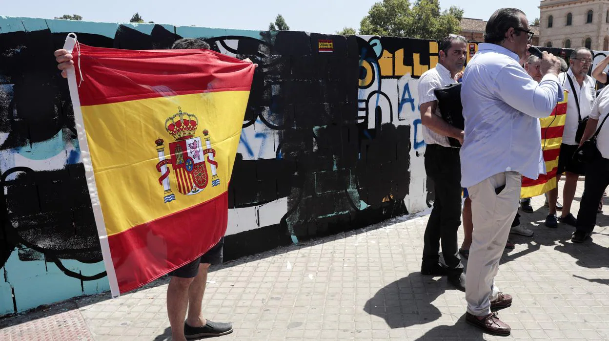 El presidente de la Federació Coordinadora d'Entitats Culturals del Regne de Valencia (FCECRV), Juan García Sentandreu (d), se dirige a los asistentes tras intentar pintar de blanco el muro de Jesuitas con un rodillo, acto que ha sido impedido por los Cuerpos de Seguridad del Estado