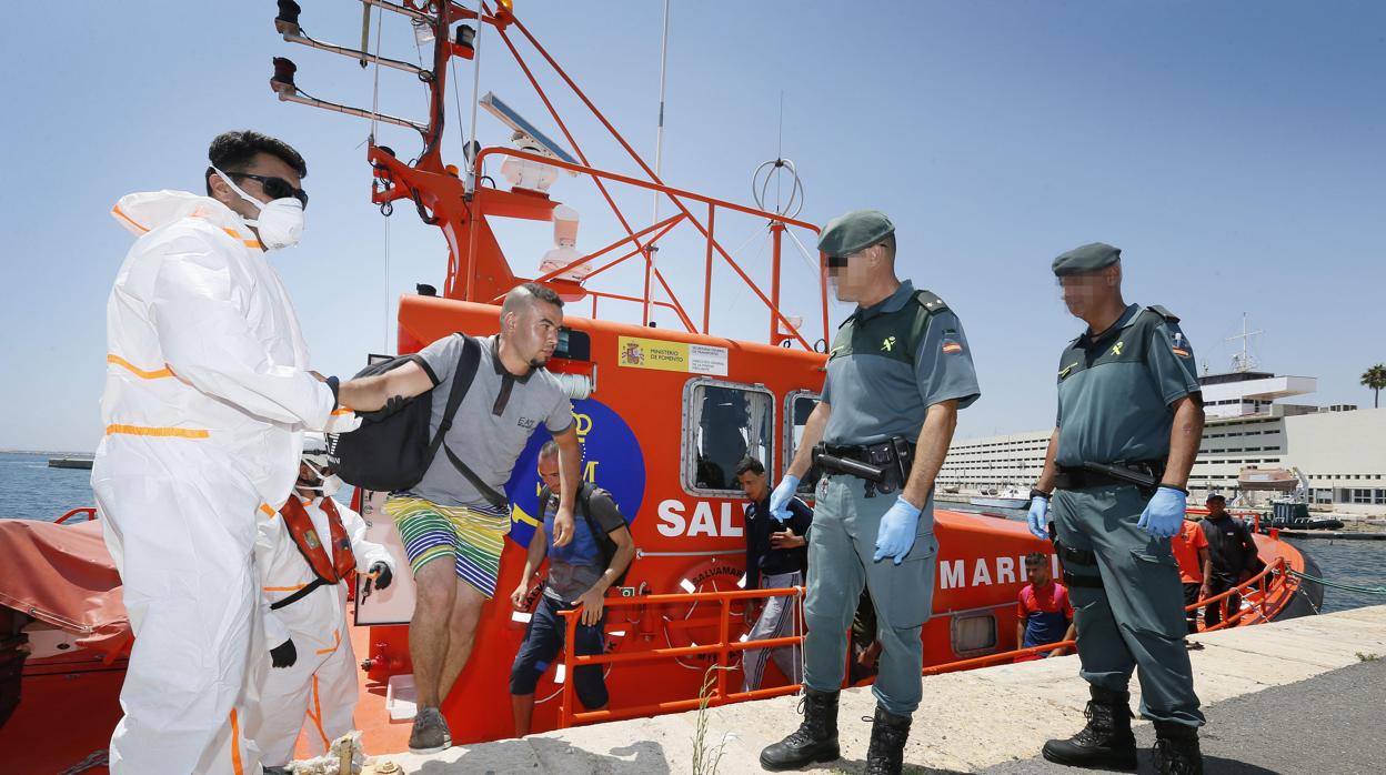 Los ocupantes de una patera bajan de un barco de Salvamento Marítimo en Alicante