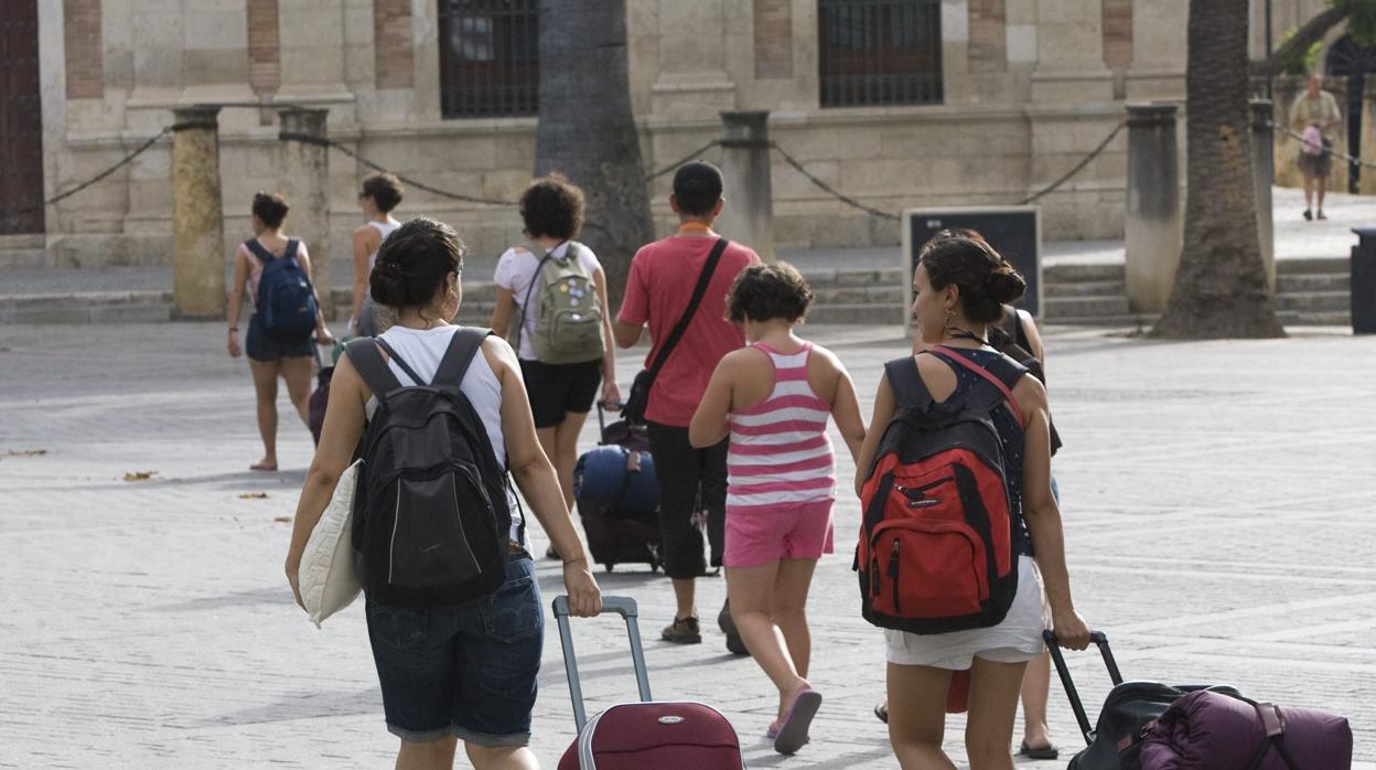 Turistas con sus maletas se dirigen a su alojamiento