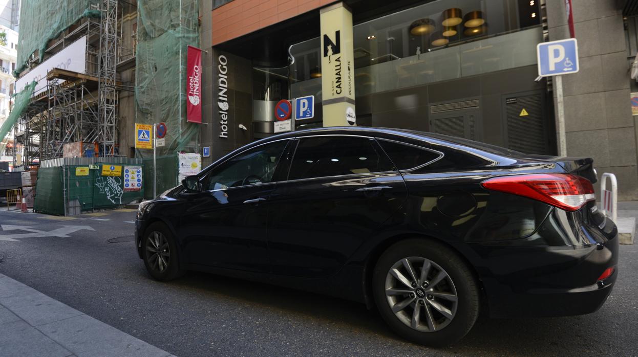 Un vehículo VTC circula frente a la entrada del hotel Indigo Madrid-Gran Vía