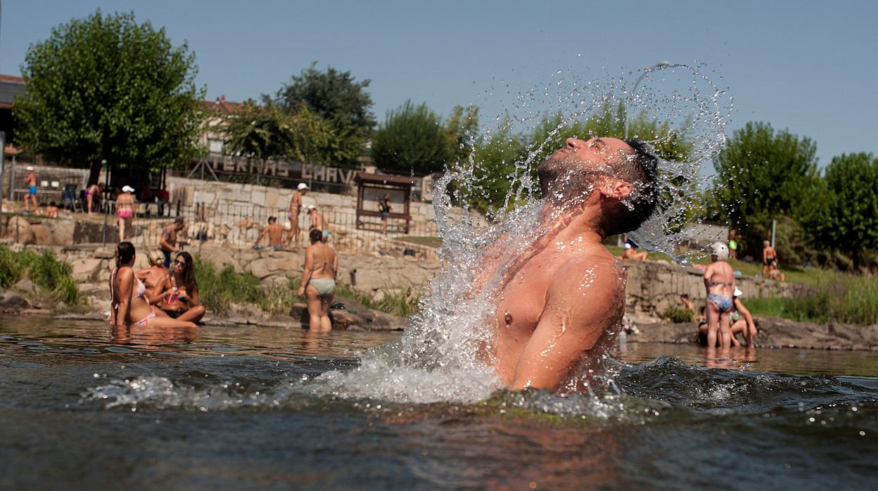 Un hombre se refresca este jueves en la zona fluvial del Miño en Orense