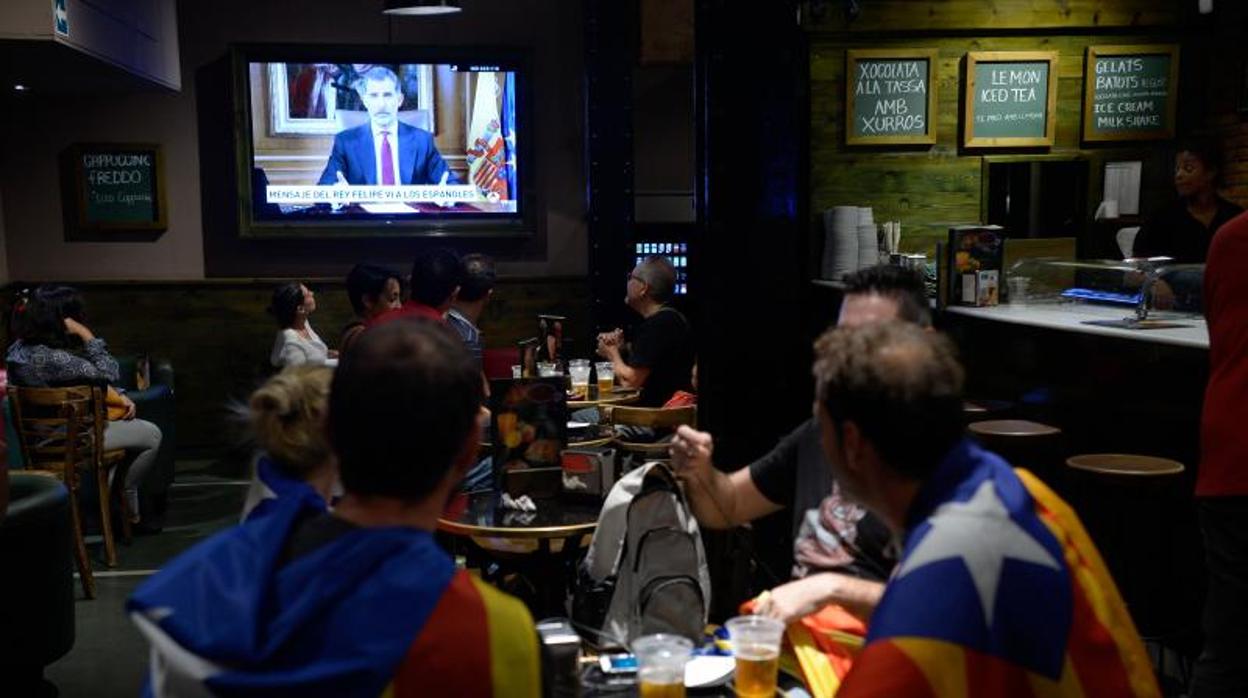 Independentistas escuchan la declaración televisada del Rey en un bar de Barcelona el 4 de octubre