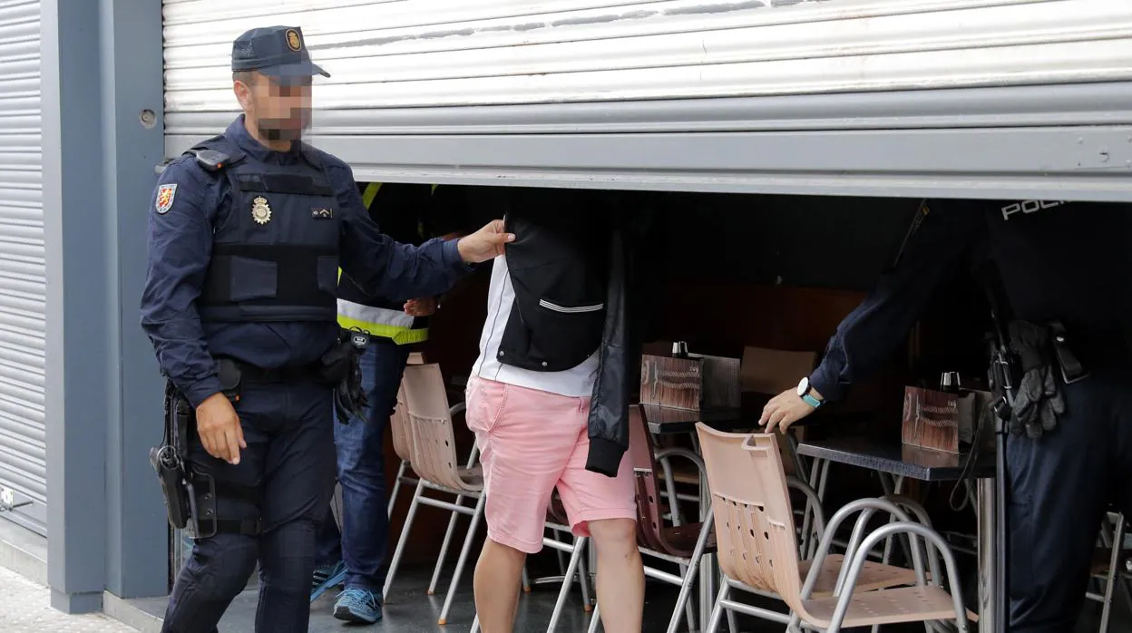 Agentes de la Policía Nacional acompañados en el registro por un detenido, inspeccionan un local de hostelería de Boiro