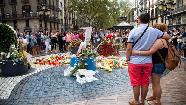 Una pareja se abraza frente al mosaico de Miró, en La Rambla, a la misma hora en la que, hace un año, se produjo el atentado