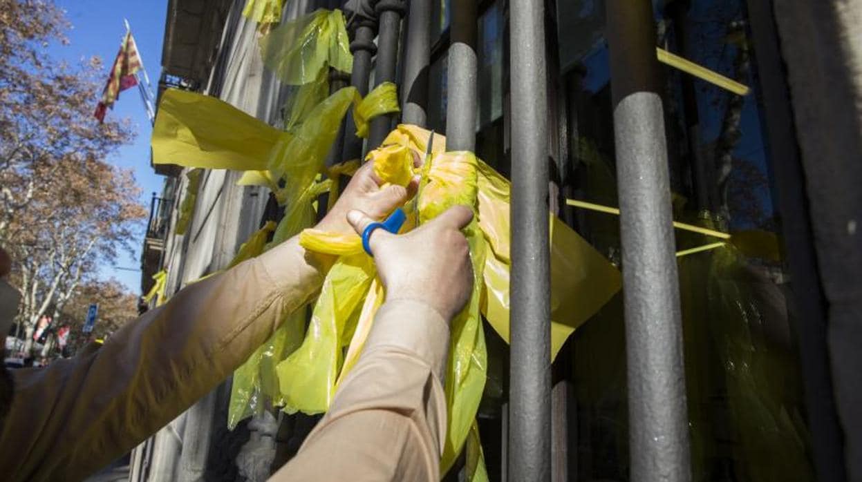 Una persona retira lazos amarillos en un edificio dependiente de la Generalitat