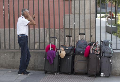 Hombre de pie junto a sus maletas en la estación de Tribunal