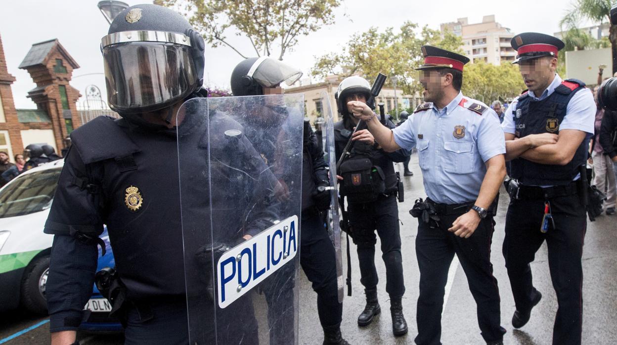 Agentes antidisturbios de la Policía Nacional y de los Mossos d' Esquadra discuten en Barcelona en el 1-O
