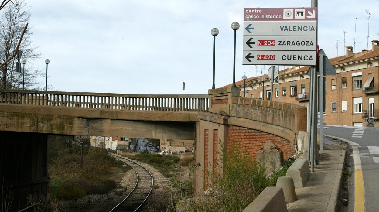 Carteles de señalización junto a desangelada línea férrea que pasa por la capital turolense