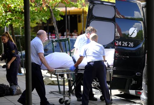 Los trabajadores de la funeraria levantan el cadaver