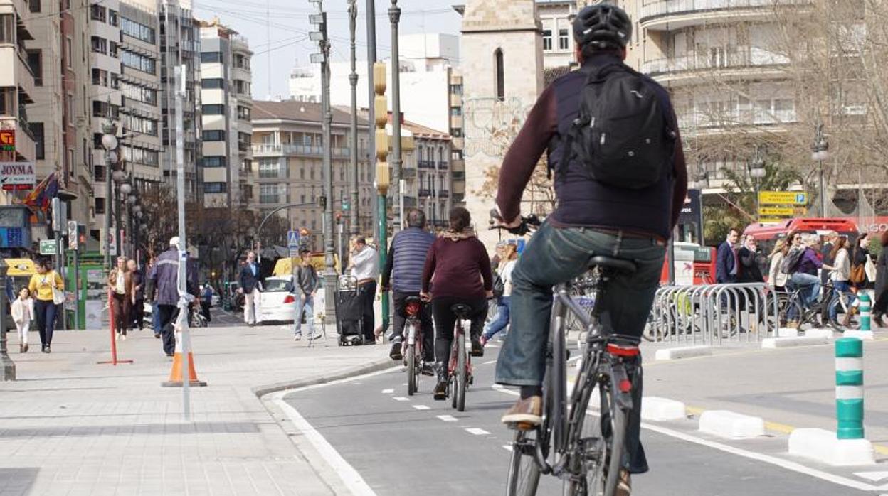 Varias personas en bici circulando por la ciudad de Valencia