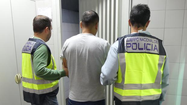 Agente de la Policía Nacional sostienen al ciudadano peruano perseguido por Interpol